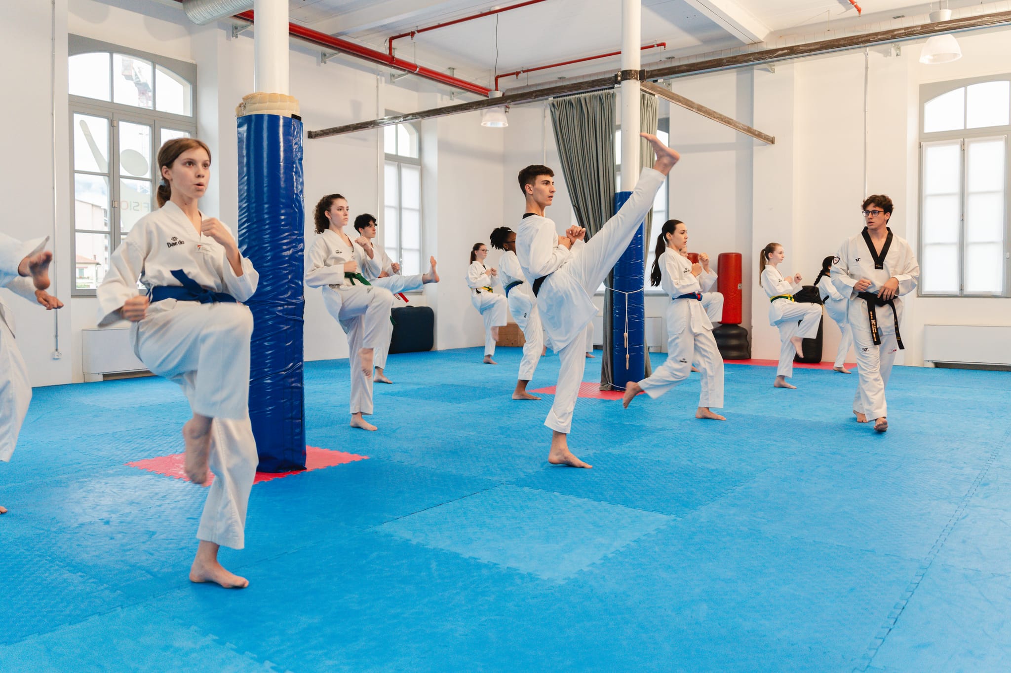 La classe esegue all'unisono un calcio frontale alto, le forme praticate insieme in palestra