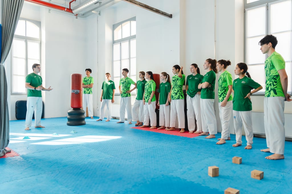 Allievi di tutte le età schierati nella palestra soleggiata della Summit durante la lezione